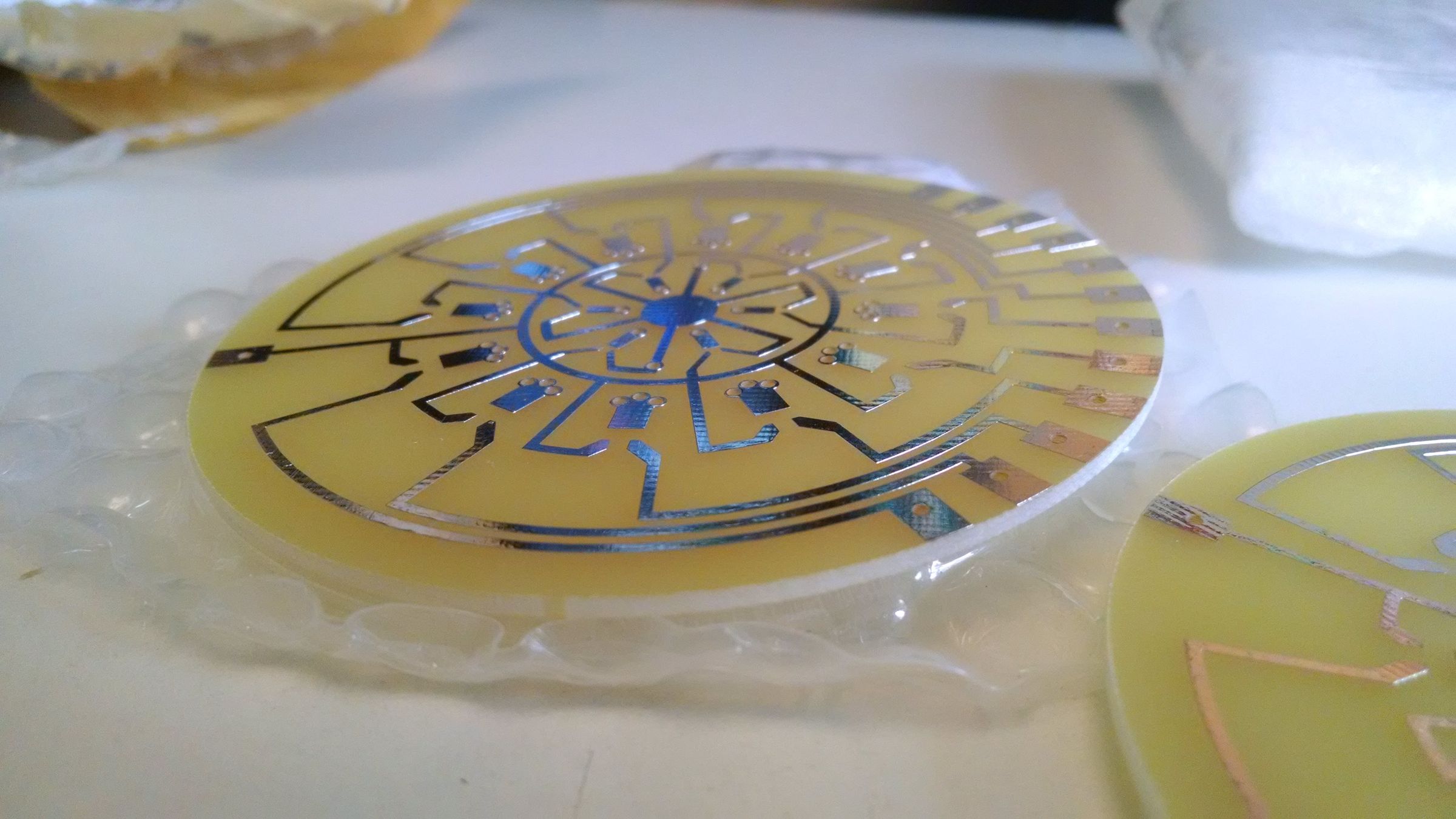 A circular printed circuit board with an intricate copper trace pattern, likely for a touch-sensitive dimmer control.