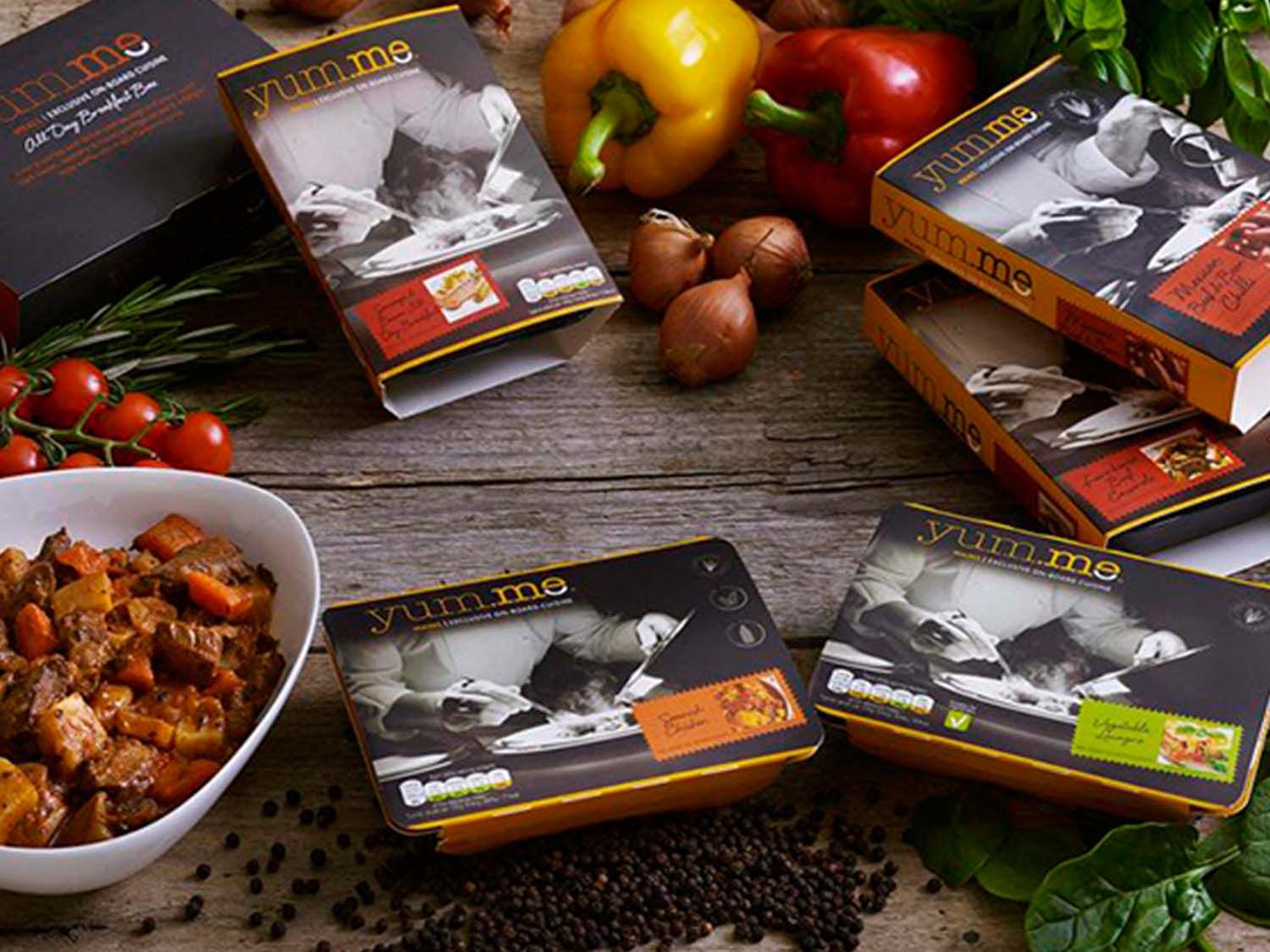 Artful photo of airline oven meals surrounded by fresh ingredients, with a focus on the packaging design